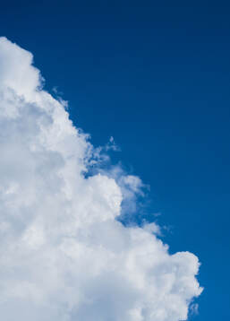 A cloud and a blue sky is seen