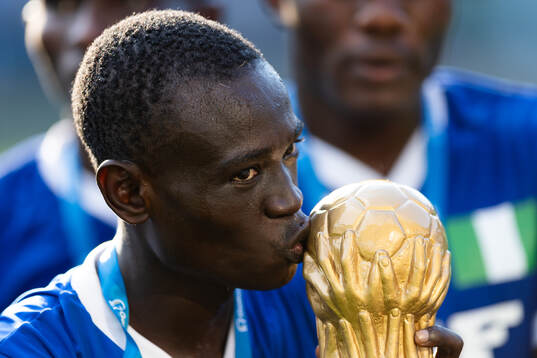 En Nigerian Eagles spelare kysser pokalen