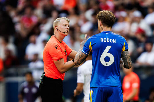 Referee Adam Ladebäck and Joe Rodon of Leeds United