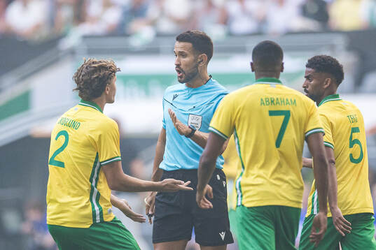 Referee Mathieu Vernice and Hampus Skoglund of Hammarby