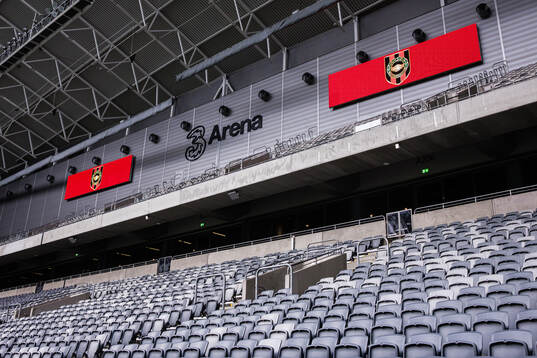 Interiör av 3Arena med Brommapojkarnas logotyper på