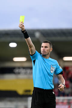 Referee Georgi Kabakov shows a yellow card