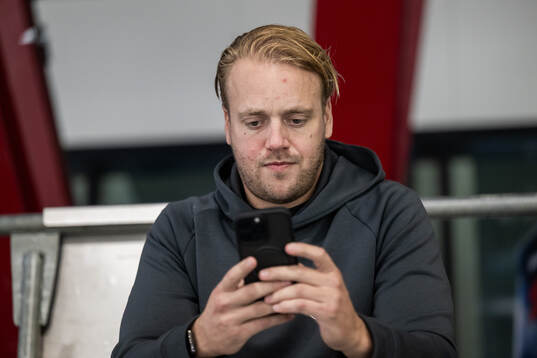 Sportchef Hampus Sjöström tittar i telefonen