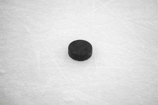 En puck på isen i KE Kelit Arena