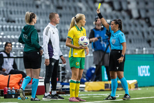 Referee Michaela Pachtova gives a yellow card to assistant