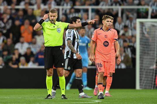 Referee Glenn Nyberg and Fermín López of Barcelona