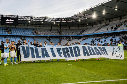 Malmö FFs spelare med en banderoll för att hedra en