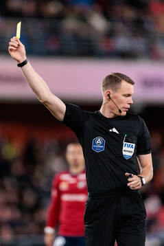 Domare Oscar Johnson delar ut ett gult kort