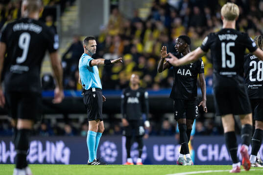 Referee Ivan Kruzliak and Pape Matar Sarr of Tottenham