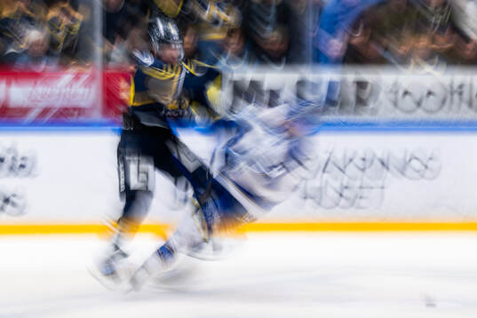 En HV71-spelare tacklar en Leksandspelare
