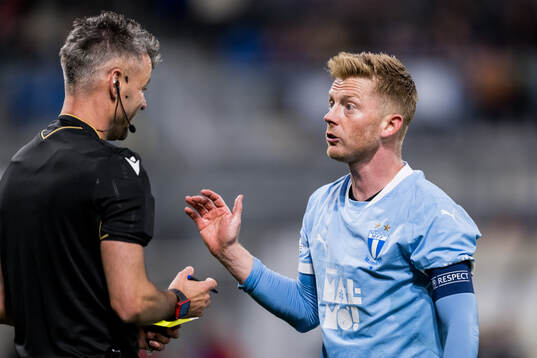 Referee Enea Jorgji and Anders Christiansen of Malmö FF