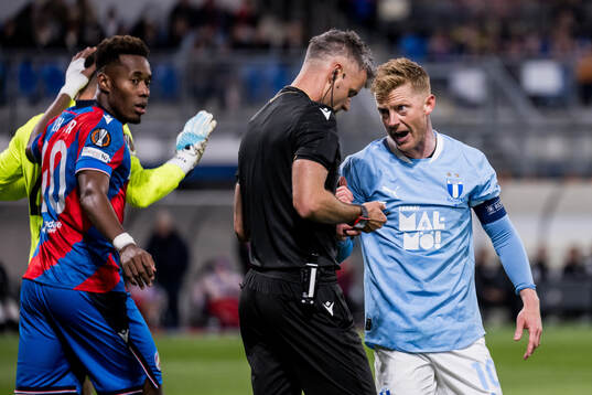 Referee Enea Jorgji and Anders Christiansen of Malmö FF
