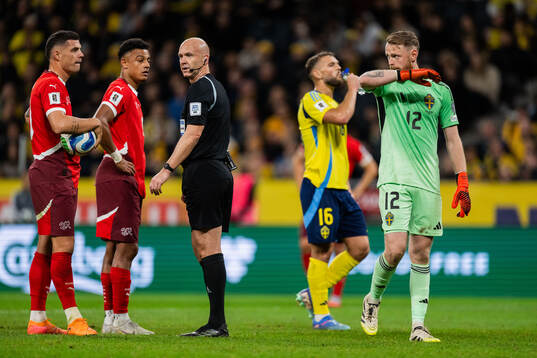 Granit Xhaka of Switzerland referee Anthony Taylor and