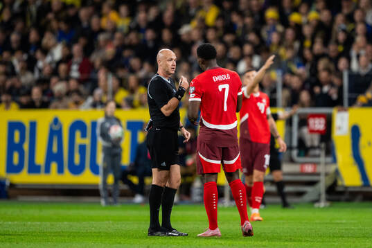 Referee Anthony Taylor and Breel Embolo of Switzerland