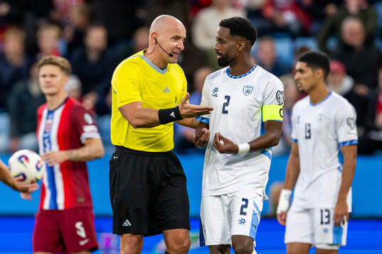 Referee Szymon Marciniak and Eli Dasa of Israel