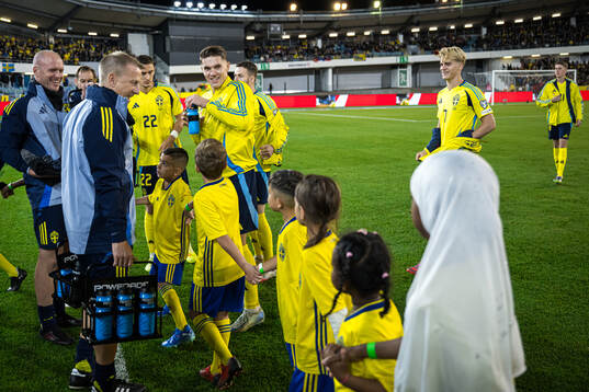 Mascots walk in front of Viktor Gyökeres and Lucas