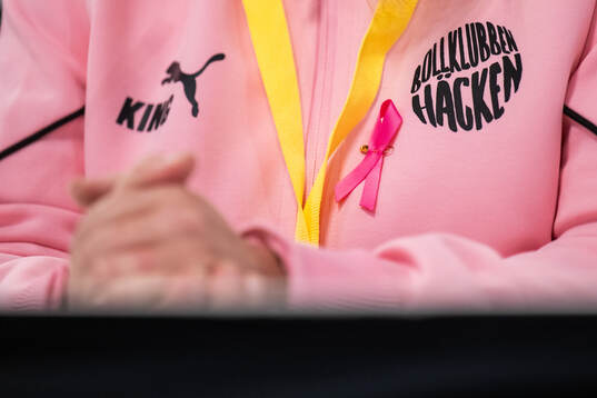 Ett Rosa Band på en träningsoverall