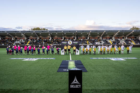 Häckens och Sirius spelare med maskotar som håller i rosa