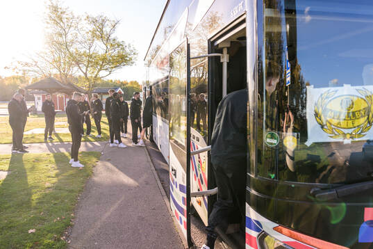 Mjällbys spelare utanför bussen vid resan mot matchen mot