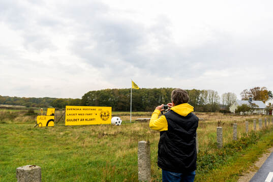 Mjällby supporter tar en bild på en skylt som hyllar laget