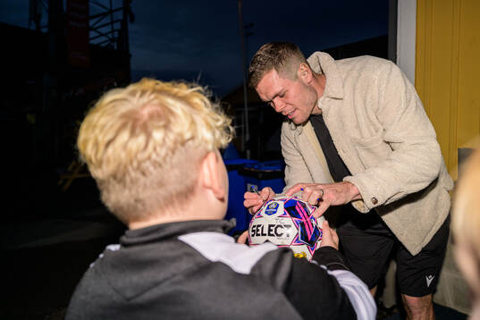 Mjällbys Jacob Bergström skriver autografer när laget