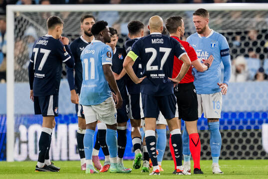 Referee Willy Delajod and Pontus Jansson of Malmö FF