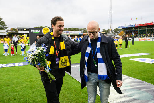 Mjällbys klubbchef Jacob Lennartsson tar emot blommor av