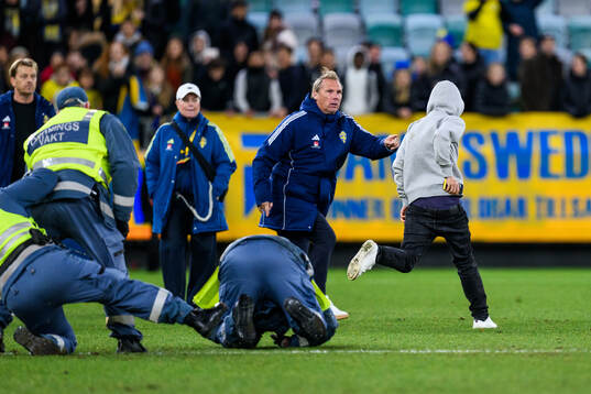 Security manager Lars From stops a pitch invader