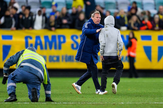 Security manager Lars From stops a pitch invader