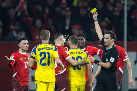 Jesper Karlström of Sweden receives a yellow card