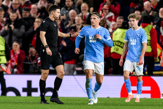 Referee Harm Osmers and Jens Stryger Larsen of Malmö FF