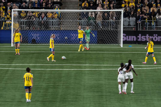 Nathalie Björn and goalkeeper Jennifer Falk of Sweden look