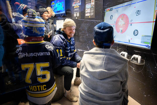 HV71s Riley Woods spelar tv-spel med besökare