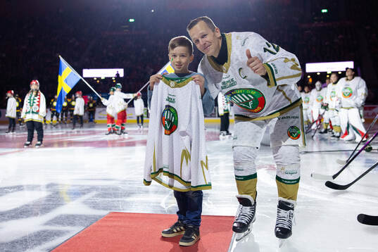Frölundas Max Friberg delar ut en matchtröja till Dawid