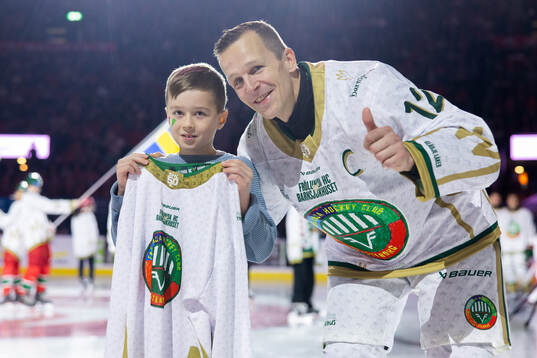 Frölundas Max Friberg delar ut en matchtröja till Dawid