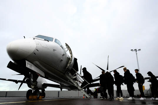 The players board the airplane