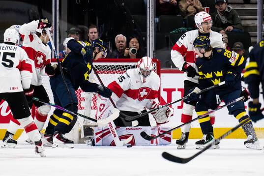 Ivar Stenberg and Eric Nilson of Sweden against goaltender