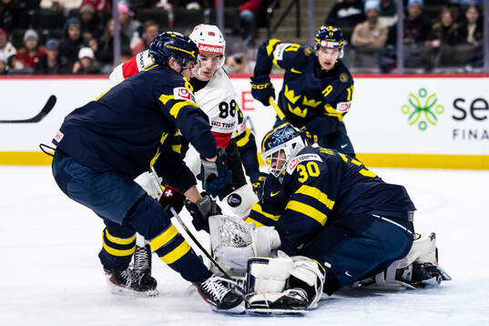 Felix Carell and goaltender Love Härenstam of Sweden