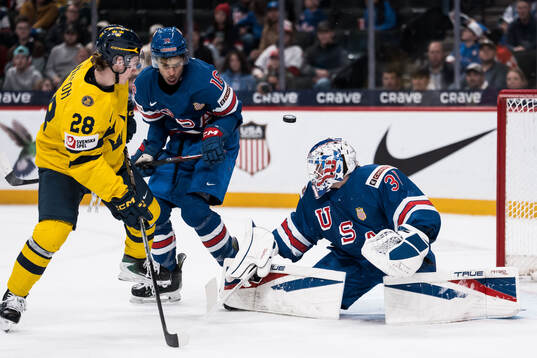 Eric Nilson of Sweden and E.J. Emery and goaltender