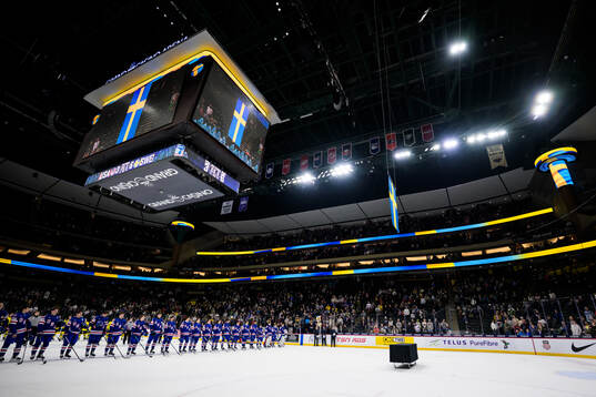 Players of Sweden and USA listen to the Swedish national