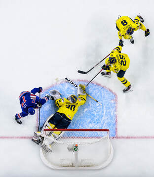 Ryker Lee of USA challenges goaltender Love Härenstam,