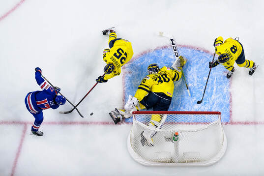 Ryker Lee of USA challenges Eddie Genborg, goaltender Love