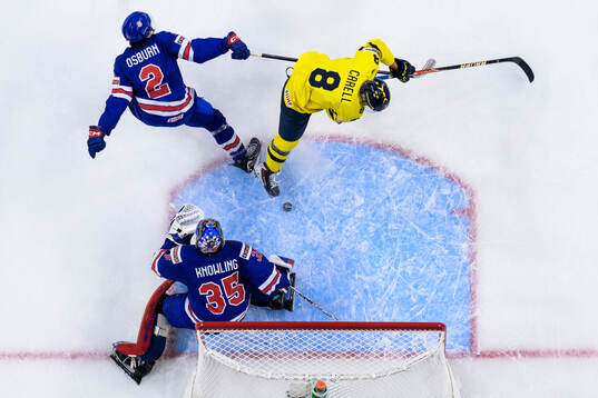 Luke Osburn and goaltender Brady Knowling of USA are being