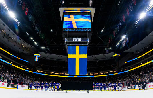 Players of Sweden and USA listen to the Swedish national