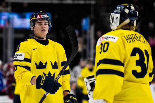 Felix Carell and goaltender Love Härenstam of Sweden