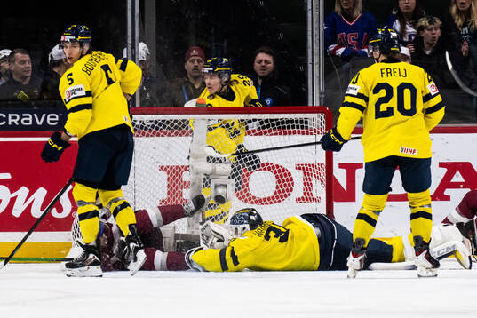 Daniels Serkins of Latvia and goaltender Love Härenstam of