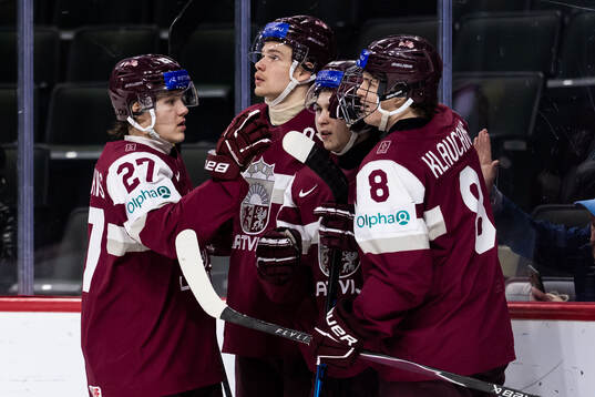 Karlis Flugins of Latvia celebrates with team mates