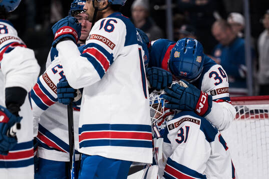 Goaltender Nicholas Kempf and Cole Eiserman of USA looks