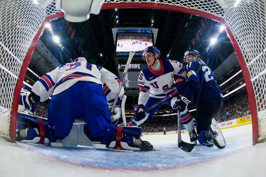 Goaltender Nicholas Kempf and Chase Reid of USA are being