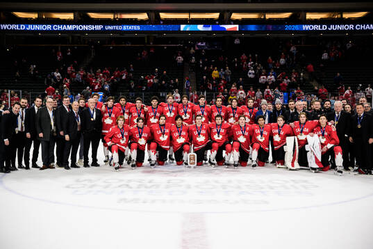 Players and coaching staff of Canada pose with the bronze